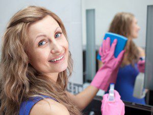 Charming Woman Cleaning A Bathroom's Mirror