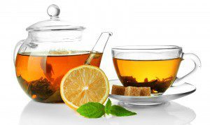 Cup and teapot of green tea with lemon and sugar isolated on whi