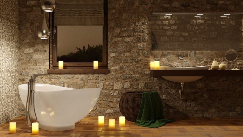 spa like bathroom with stone walls candles and deep soaking bathtub