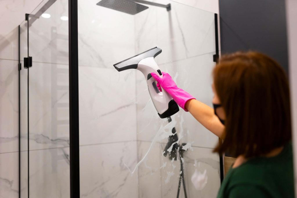 squeegee cleaning soap scum off shower door